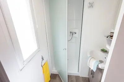 a white bathroom with a sink and a shower at Eurocamp Mobile Homes Terme Catez in Brežice