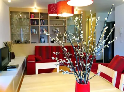a red vase with flowers in a living room at Apartment Happy Place in Bohinj
