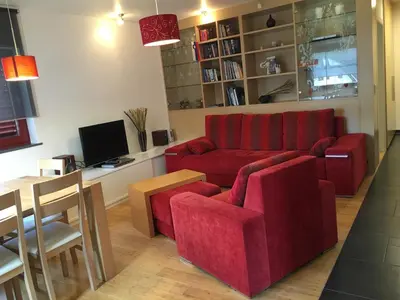 a living room with a red couch and a table at Apartment Happy Place in Bohinj