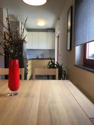 a red vase sitting on top of a wooden table at Apartment Happy Place in Bohinj