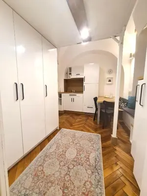 a living room with white cabinets and a table at Courtyard Studio City Center in Ljubljana