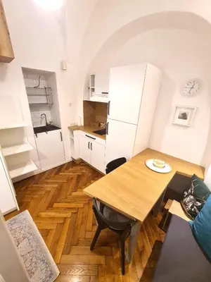 a small kitchen with a wooden table and a dining room at Courtyard Studio City Center in Ljubljana