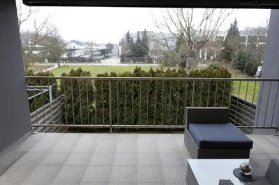 a balcony with a chair and a view of a park at Lazy Haven in Moravske Toplice