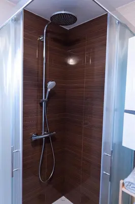 a bathroom with a shower with wooden walls at Lazy Haven in Moravske Toplice