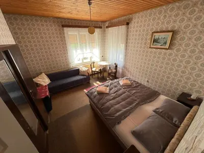 a bedroom with a bed and a living room at Apartma Prisojnik in Kranjska Gora