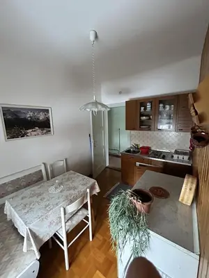a living room with a table and a kitchen at Apartma Prisojnik in Kranjska Gora