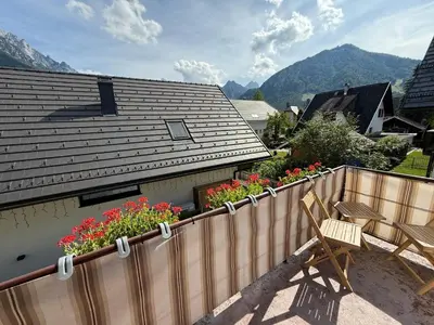 a house with a wooden fence and some flowers at Apartma Prisojnik in Kranjska Gora