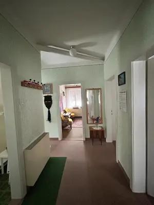a living room with a ceiling fan and a hallway at Apartma Prisojnik in Kranjska Gora