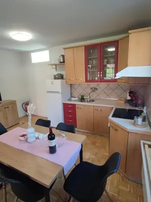 a kitchen with a table with a bottle of wine on it at Apartment by MICHELLE - Terme Čatež House in Čatež ob Savi