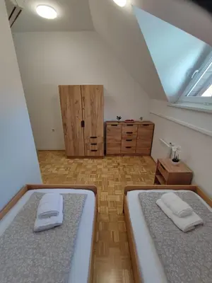 a attic bedroom with two beds and a window at Apartment by MICHELLE - Terme Čatež House in Čatež ob Savi