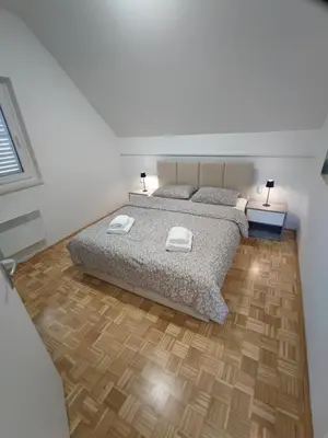 a bedroom with a bed and a wooden floor at Apartment by MICHELLE - Terme Čatež House in Čatež ob Savi