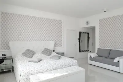 a white bedroom with a bed and a couch at SLOAPART Apartments in Rogaška Slatina