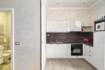 a kitchen with white cabinets and a sink at SLOAPART Apartments in Rogaška Slatina
