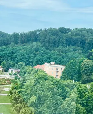 a building in the middle of a forest of trees at SLOAPART Apartments in Rogaška Slatina