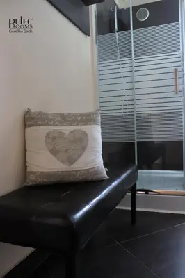 a black leather bench with a heart pillow on it at Apartma Sobe Pulec in Dobrovo