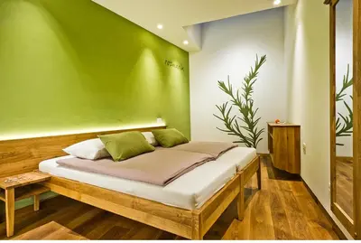 a bed in a room with a green wall at Majerija in Vipava