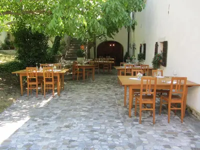 a restaurant with wooden tables and chairs on a patio at Majerija in Vipava