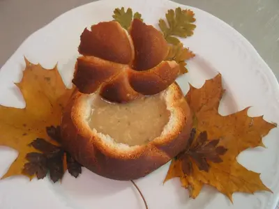 a white plate with a sandwich on top of autumn leaves at Majerija in Vipava