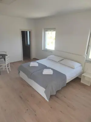 a bedroom with a large bed with two towels on it at Studio Apartma KIMI in Nova Gorica