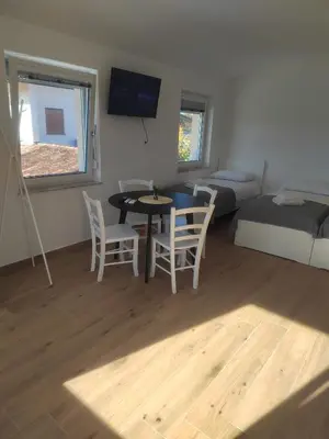 a living room with a table and chairs and a bed at Studio Apartma KIMI in Nova Gorica