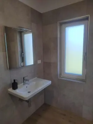 a bathroom with a sink and a window at Studio Apartma KIMI in Nova Gorica