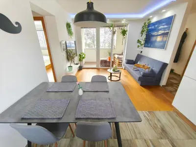 a dining room and living room with a table and chairs at Family Nest near Ljubljana with free parking in Dobrova
