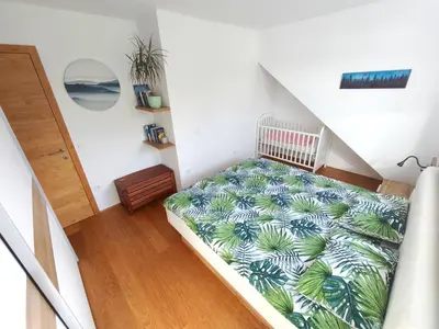 a bedroom with a bed with a green plant on it at Family Nest near Ljubljana with free parking in Dobrova