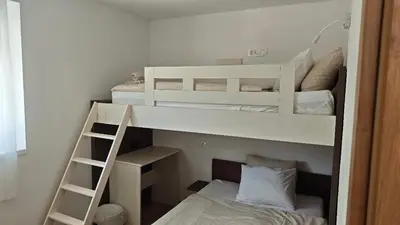 two bunk beds in a room with a ladder at Apartma Mia Nadiža in Kobarid