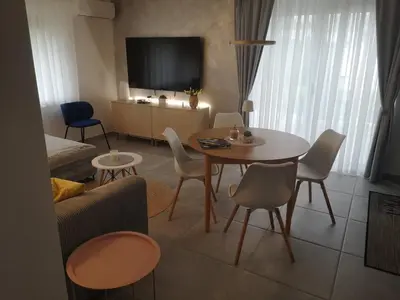 a living room with a table and chairs and a tv at Apartma Mia Nadiža in Kobarid