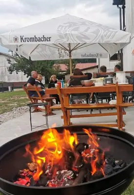 a fire pit with people sitting at a table at Apartma Mia Nadiža in Kobarid