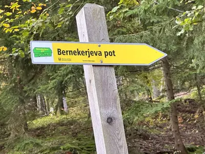 a yellow sign on a wooden post at Apartments Barbra - Robinson life in Slovenj Gradec