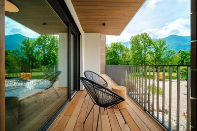 a screened porch with two chairs on a deck at Family apartments Soča Splash Home in Bovec