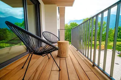 a porch with a bench on a balcony at Family apartments Soča Splash Home in Bovec