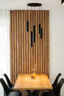 a dining room table with black chairs and a chandelier at Family apartments Soča Splash Home in Bovec