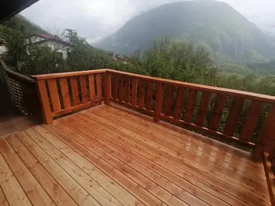 a wooden deck with a view of a mountain at Apartment Pri Bricu in Kobarid