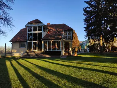 a house on a grassy field with a tree at House IZI - parking, garden, 8 min ride to center in Maribor