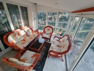 a room with chairs and a couch and windows at House IZI - parking, garden, 8 min ride to center in Maribor