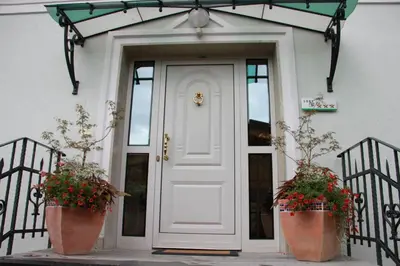a white door with two large flower pots in front of it at Vila Krivec in Bled