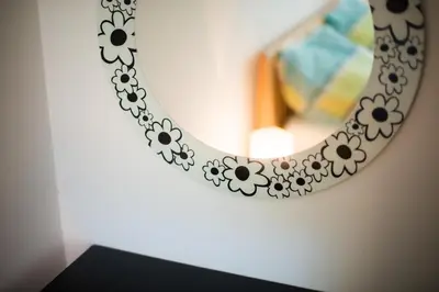 a mirror on a wall next to a shelf at Apartment Ani in Bled