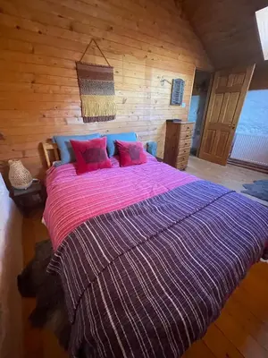 a bedroom with a large bed with red pillows at Nadiza Hilltop Retreat in Breginj