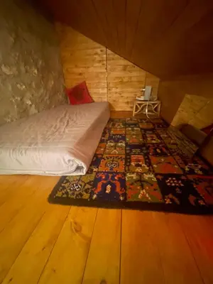 a bedroom with a bed and a rug on a wooden floor at Nadiza Hilltop Retreat in Breginj