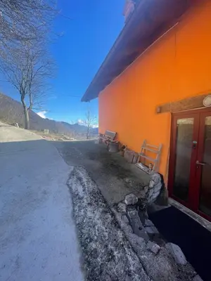 an orange building with a bench on the side of it at Nadiza Hilltop Retreat in Breginj