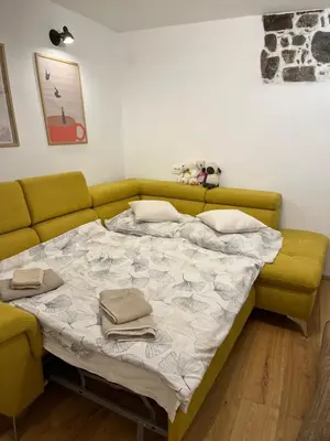 a bed in a room with a green couch at Apartment Rozalka Vipava valley in Podnanos