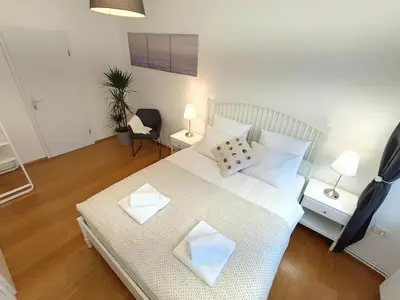 a bedroom with a large white bed with two pillows at Two-bedroom city apartment in Ljubljana