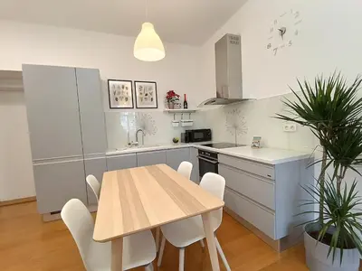 a kitchen with a wooden table and a table and chairs at Two-bedroom city apartment in Ljubljana