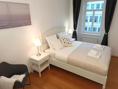 a small bedroom with a bed and a window at Two-bedroom city apartment in Ljubljana