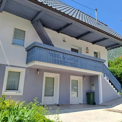 a building with a balcony with a blue railing at Apartments Rupnik in Bovec
