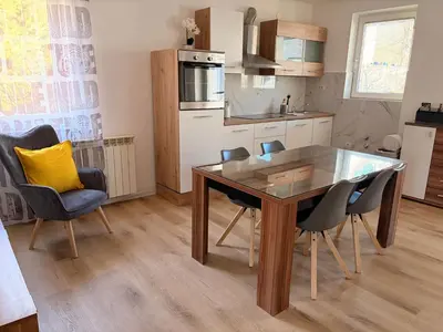 a kitchen with a dining room table and chairs at Apartments Rupnik in Bovec