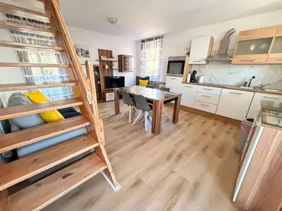 a room with a table and a kitchen with a bunk bed at Apartments Rupnik in Bovec