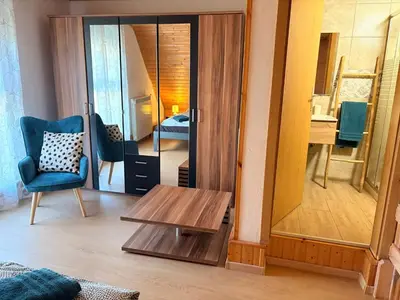 a living room with a table and a mirror at Apartments Rupnik in Bovec